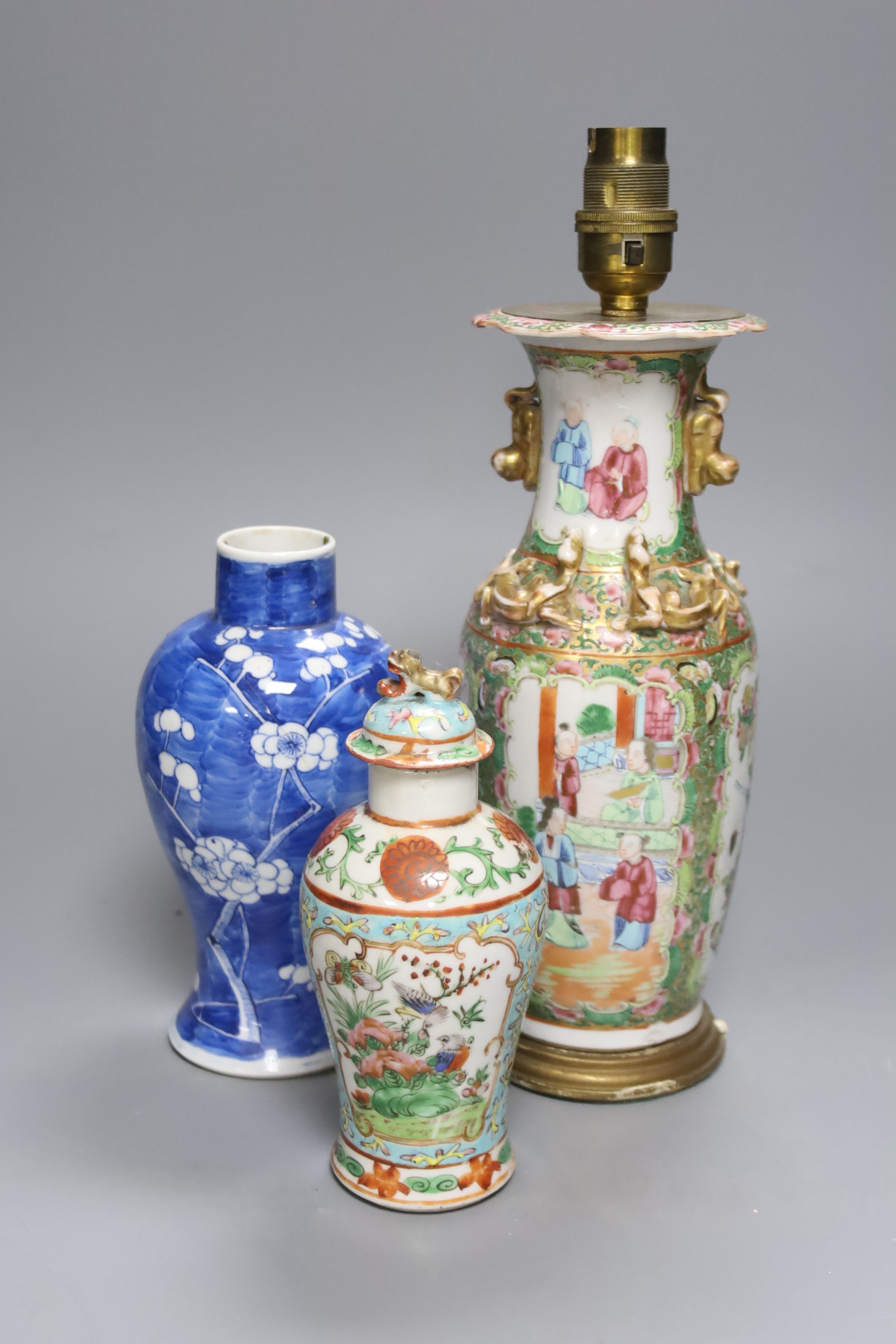 A Chinese famille rose converted lamp, a similar blue and white vase and another vase and cover, overall height 32cm